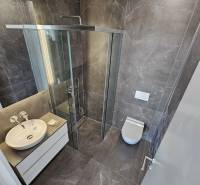 A nyaraló apartman fürdőszobája tágas zuhanyzóval és modern felszereléssel.