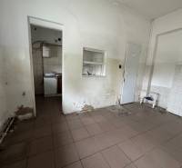 Az épület belső tere sérült falakkal és csempékkel, felújításra alkalmas.