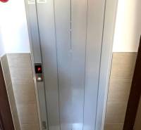 Lift egy háromszobás lakásban, az ingatlanügynökség logójával az ajtón.
