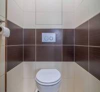 WC barna-fehér csempékkel egy háromszobás lakásban.