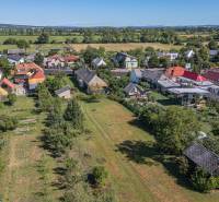 Légi felvétel a Sečovce-i lakóterületekről, amelyeket zöld területek és elszórt házak vesznek körül.