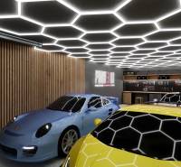 Kereskedelmi helyiségek parkoló sportautókkal és modern mennyezeti világítással.
