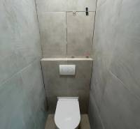 Két szobás lakás fürdőszobai helyiségei WC-vel és csempével.