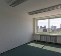 Üres iroda kilátással a város panorámájára egy nagy ablakon keresztül.