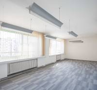 Tágas irodák függőlámpákkal és függőleges redőnyökkel.