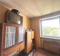 Retró bútorok és televízió egy háromszobás lakásban, kilátással az ablakon keresztül.