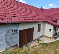 Családi ház a Vranov nad Topľou Dlhá utcáján, piros tetővel és garázskapukkal.