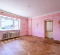 Rózsaszín falak virágdíszítéssel, fa padló, nagy ablak egy családi házban.