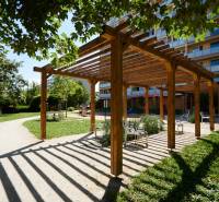 Fából készült pergola padokkal a kassai parkban, Juh városrész, zölddel körülvéve.