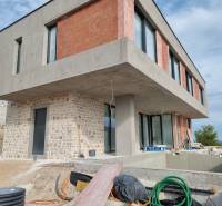 Folyamatban lévő villa Vodicében beton- és téglahomlokzattal, medencével és verandával.