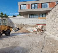 Építkezési terület egy félkész villával Vodice városában, látható egy építőgép és anyag.