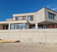 Egy villa külseje Vodice-ben modern ablakokkal és nyers betonnal.