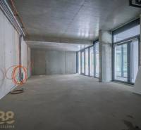 Üzlethelyiség belső tér üvegfallal, betonmennyezettel és elektromos berendezéssel.