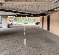 Garázs belső tér parkolóhelyekkel és kijárattal a Sadová utcára Szenicén.