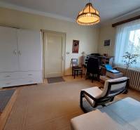 Nappali egy családi házban egy fotellel, íróasztallal és komóddal.