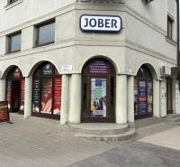 Komárom, Petőfi utca, üzlethelyiségek reklámtáblákkal és több bejárattal.