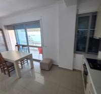 Étkező sarok tengerre néző kilátással egy nyaraló apartmanban, világos belső berendezéssel.