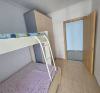 Gyerekszoba emeletes ággyal egy üdülő apartmanban világos falakkal és padlóval.