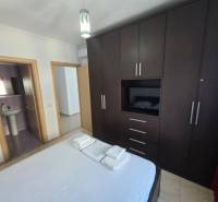 Hálószoba egy üdülő apartmanban nagy gardróbszekrénnyel és csatlakoztatott fürdőszobával.
