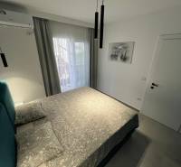 Rekreációs apartman kényelmes ággyal, légkondicionálóval és erkélyajtókkal, kilátással.