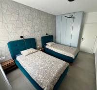 Kétszemélyes szoba kék ágyakkal és mintás fallal a Nyaraló apartmanban.