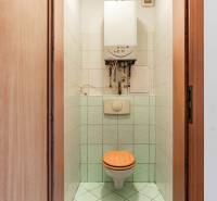 Fürdőszoba WC-vel és bojlerrel egy kétszobás lakásban, csempével burkolva.