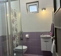 Fürdőszoba csempékkel családi házban, zuhanyzó, mosdó, WC.