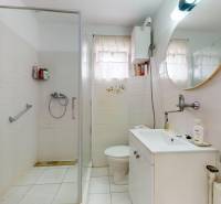 Fürdőszoba mosdóval, zuhanyzóval és WC-vel egy családi házban.