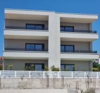 Háromemeletes, üvegezett erkélyes lakóház Vodice városában.