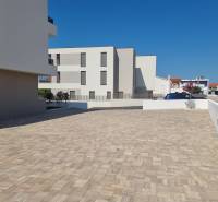 Négy szobás lakás parkolója Vodice városában szilárd burkolattal és tiszta építészettel.