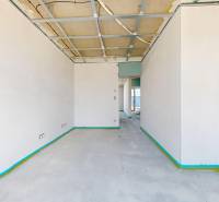 Üres belső tér betonpadlóval és építés alatt álló mennyezettel egy családi házban.