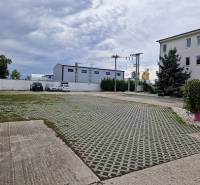 Šamorínska utca parkolója a raktárak és csarnokok mellett, ingatlanügynökség jelzésével.