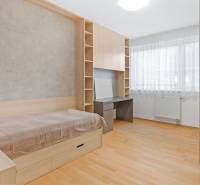 Világos szoba ággyal, íróasztallal és ablakkal egy 4 szobás lakásban.