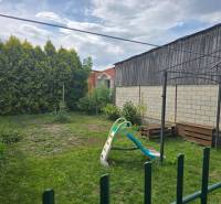 Egy 4 szobás lakás kertje Kocovce-ban hintával és zöld növényzettel.