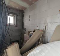 Stavebné materiály a elektroinštalácia v rozpracovanej miestnosti rodinného domu.