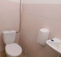 WC mosdóval és szappanadagolóval ipari épületben.
