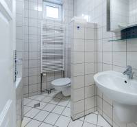 Fürdőszoba WC-vel, mosdóval és ablakkal egy családi házban. Csempézett burkolatok.