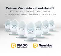 Reklám egy díjnyertes ingatlanirodára üveg trófeákkal és RADO group logókkal.