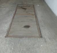 Betonpadló a garázsokban középen egy aknafedéllel.