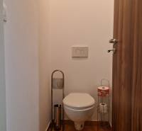 Fürdőszoba WC-vel és WC-papír tartókkal az egyszobás lakásban.