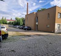 Tehelnej utcai parkoló Pezinkben autókkal és épülettel, hely egy egyszobás lakás számára.