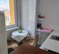 Konyha egy kétszobás lakásban ablakkal, bárpulttal és étkező sarokkal.