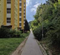 Sárga lakóház a Moszkva utcában Besztercebányán, a járda és a zöldterület mellett.