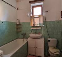 Fürdőszoba családi házban káddal, mosdóval és WC-vel, zöld csempékkel.