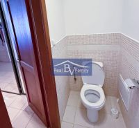 WC egy kétszobás lakásban egyszerű csempével és világos padlóburkolattal.