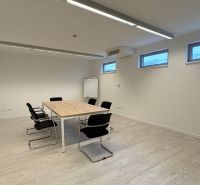 Irodák fa dekorációjú padlóval, konferenciaasztallal és székekkel.