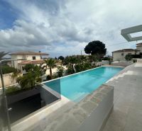 Villa Benissében medencével, pálmafákkal és kilátással más házakra és az égre.