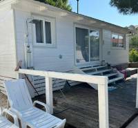 Fehér faház napozóágyakkal a kavicsos teraszon Vodice városában, Horvátországban.