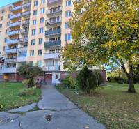 A Komenského utcai háromszobás lakásokkal rendelkező épület Pöstyénben, fákkal és zölddel körülvéve.