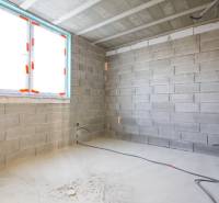 Belső tér befejezetlen falakkal, elektromos kábelek szerelésével és ablakkal egy családi házban.